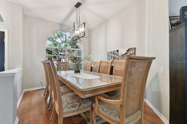 dining room with hardwood / wood-style floors and a notable chandelier