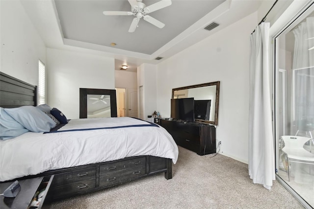 bedroom featuring ceiling fan, light colored carpet, connected bathroom, and a raised ceiling