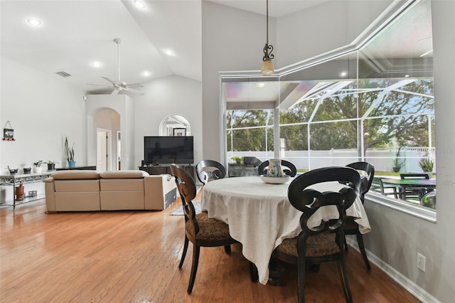 dining area featuring ceiling fan, a wealth of natural light, lofted ceiling, and wood-type flooring