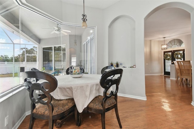 dining space with wood-type flooring and ceiling fan