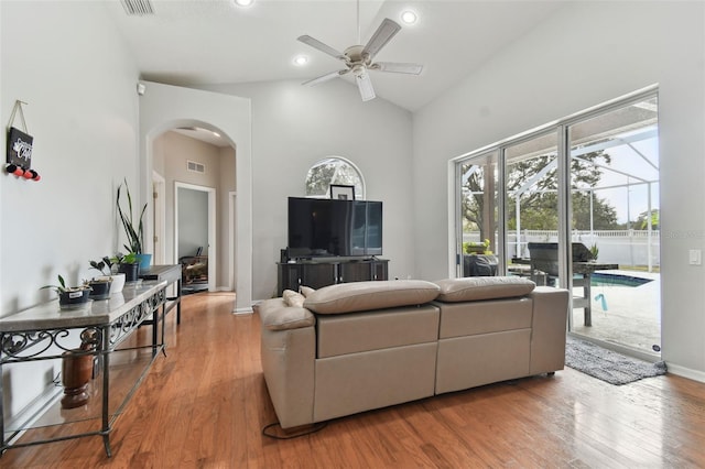 living room featuring wood-type flooring, high vaulted ceiling, and ceiling fan