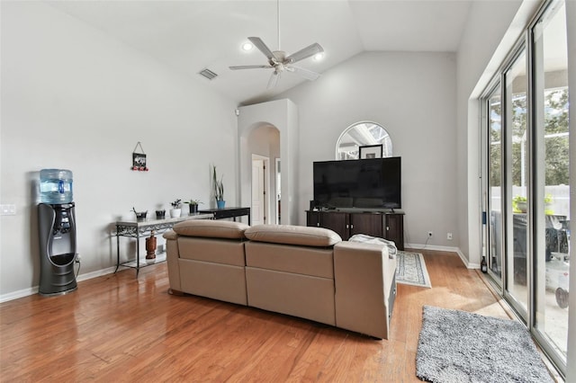 living room with ceiling fan, light hardwood / wood-style flooring, and high vaulted ceiling