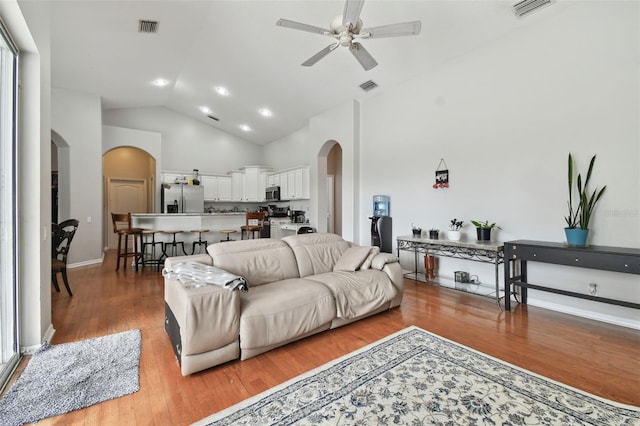 living room featuring ceiling fan, high vaulted ceiling, and hardwood / wood-style floors