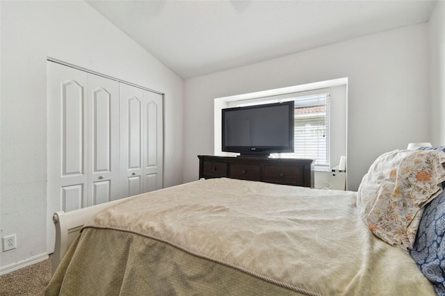 carpeted bedroom featuring a closet and lofted ceiling