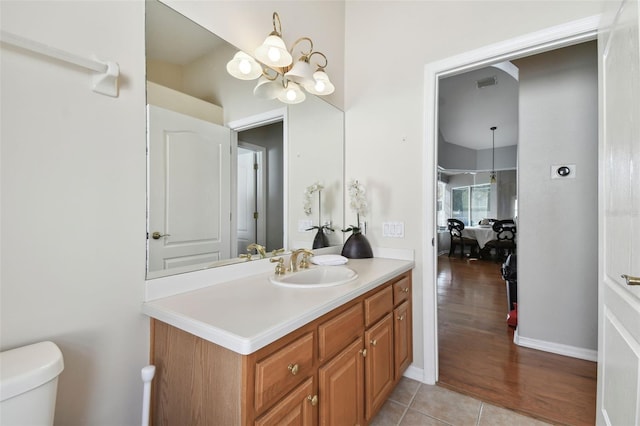 bathroom featuring tile patterned flooring, vanity, toilet, a chandelier, and a shower with shower door