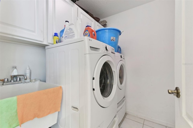 laundry area featuring sink, independent washer and dryer, cabinets, and light tile patterned flooring