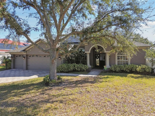 view of front of property with a garage and a front lawn