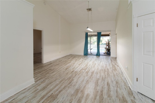 empty room featuring a high ceiling and light hardwood / wood-style flooring