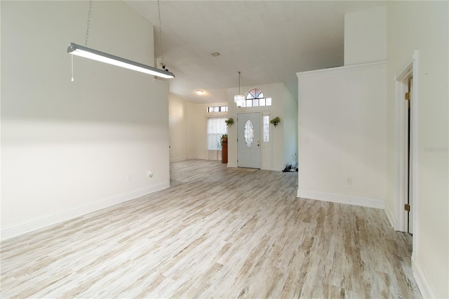 unfurnished living room featuring high vaulted ceiling and light hardwood / wood-style floors