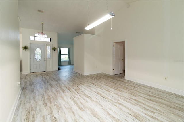 entrance foyer featuring high vaulted ceiling and light hardwood / wood-style floors