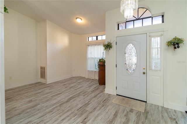 entrance foyer with a notable chandelier and light hardwood / wood-style flooring