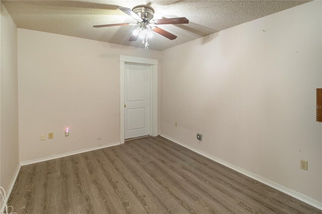 empty room featuring ceiling fan, wood-type flooring, and a textured ceiling