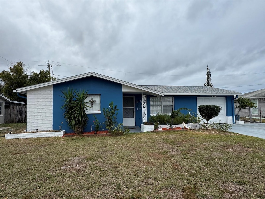 single story home with a garage and a front lawn