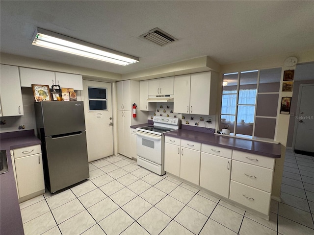 kitchen featuring white cabinets, white range with electric cooktop, decorative backsplash, stainless steel refrigerator, and light tile patterned floors