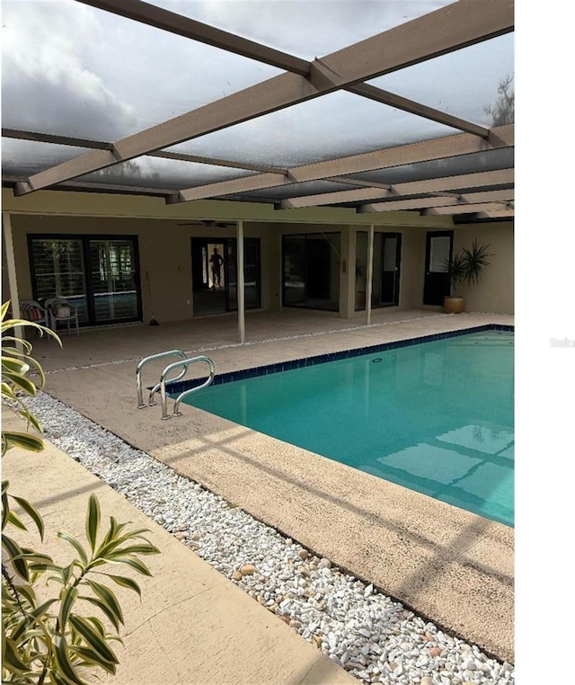 view of swimming pool featuring a lanai and a patio