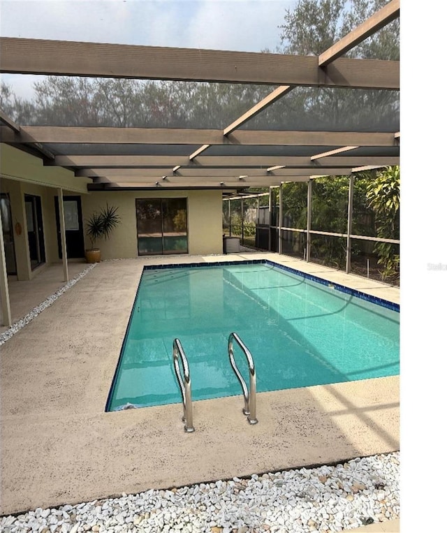 view of swimming pool with a patio area and glass enclosure