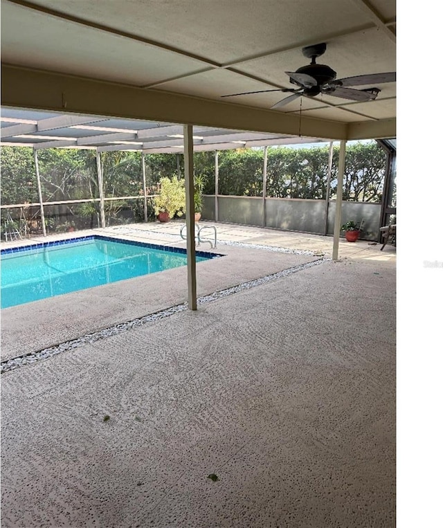 view of pool featuring a patio, ceiling fan, and glass enclosure