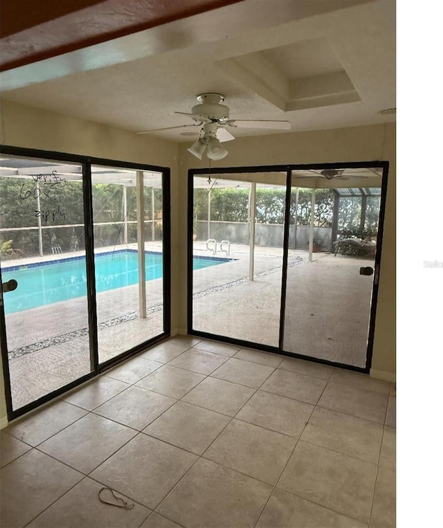 doorway featuring light tile patterned flooring and ceiling fan