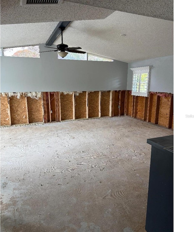 miscellaneous room featuring a textured ceiling, vaulted ceiling, and ceiling fan