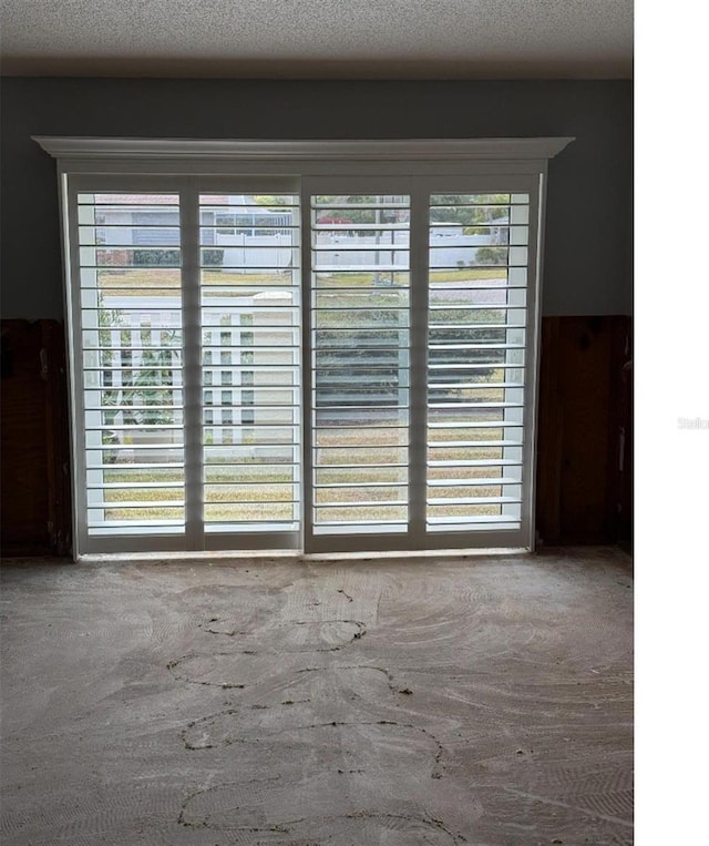 empty room with plenty of natural light and a textured ceiling