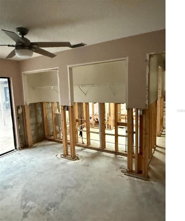 misc room with ceiling fan and concrete floors