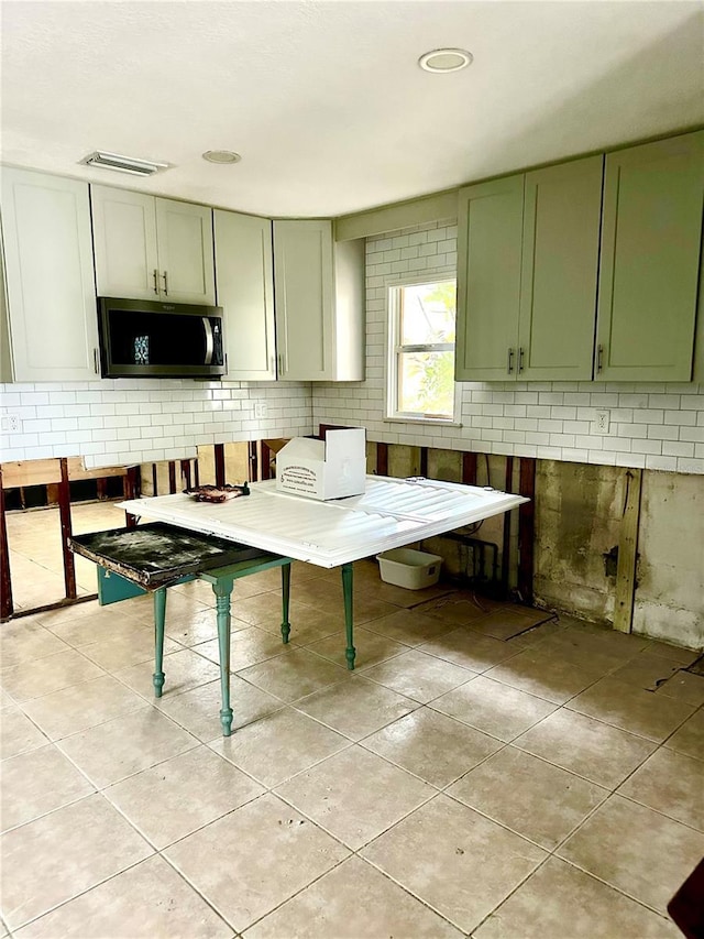 kitchen featuring green cabinetry and light tile patterned floors