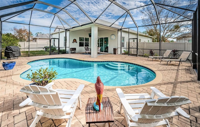 view of swimming pool with grilling area, a lanai, and a patio