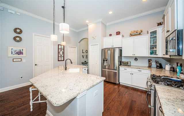 kitchen with a kitchen island with sink, sink, stainless steel appliances, and a breakfast bar