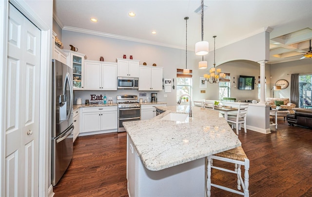 kitchen with a breakfast bar, sink, white cabinetry, a large island with sink, and stainless steel appliances