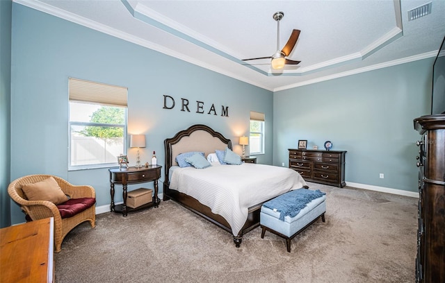 carpeted bedroom featuring ornamental molding, ceiling fan, and a tray ceiling