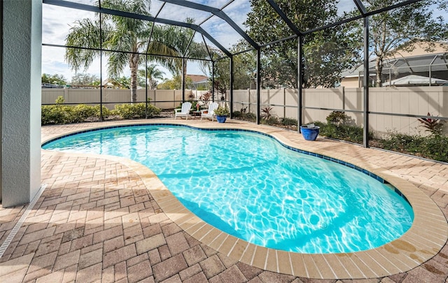 view of swimming pool featuring a patio area and glass enclosure