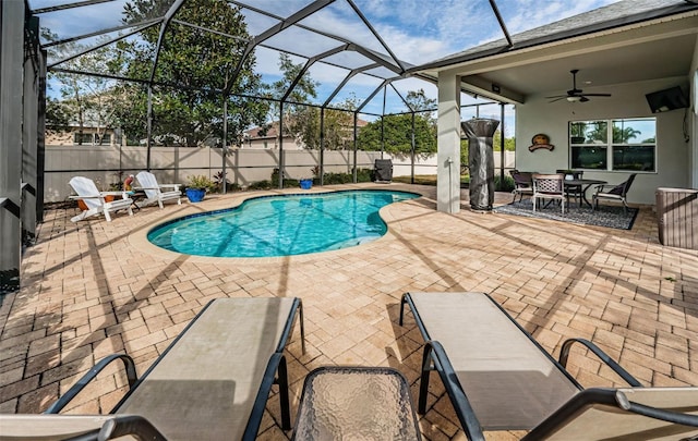 view of pool featuring glass enclosure, ceiling fan, and a patio area