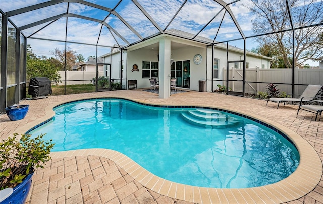 view of swimming pool with grilling area, a patio area, and glass enclosure