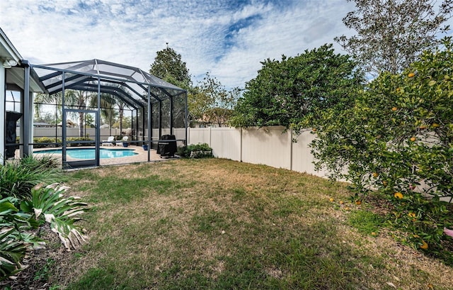 view of yard with a lanai and a fenced in pool