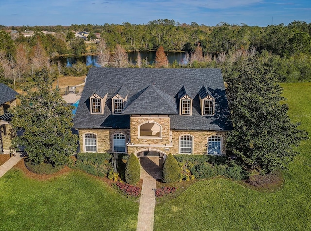 view of front of house with a water view and a front lawn