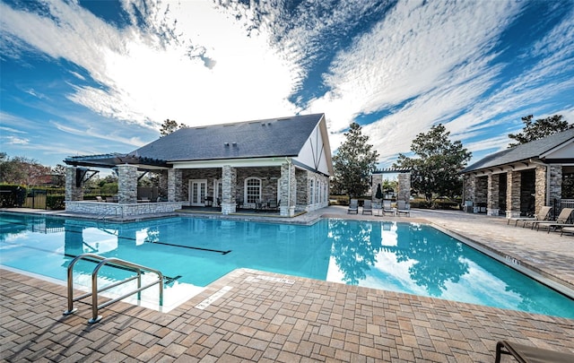 view of swimming pool featuring an outdoor structure, a pergola, and a patio area