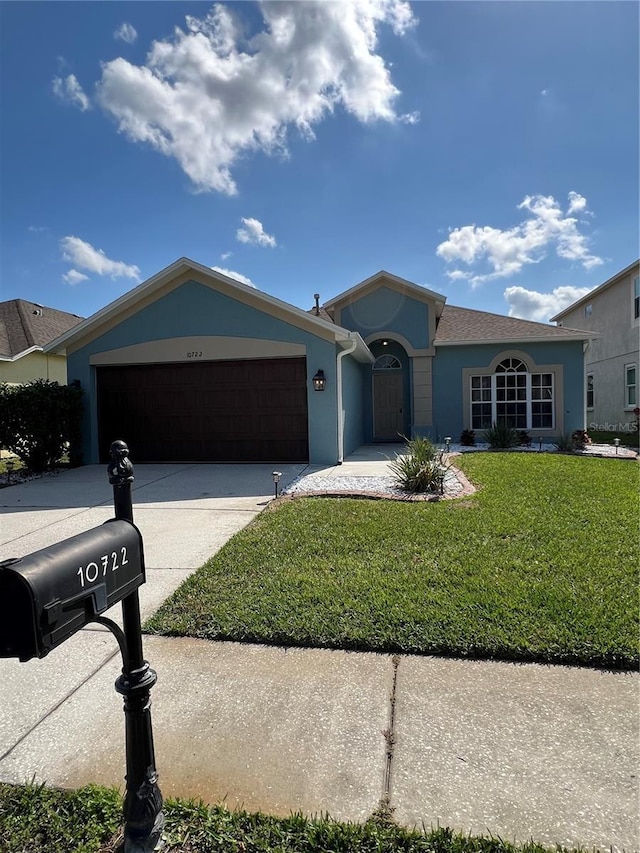 ranch-style house featuring a garage and a front lawn