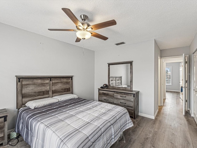 bedroom featuring wood-type flooring, a textured ceiling, and ceiling fan