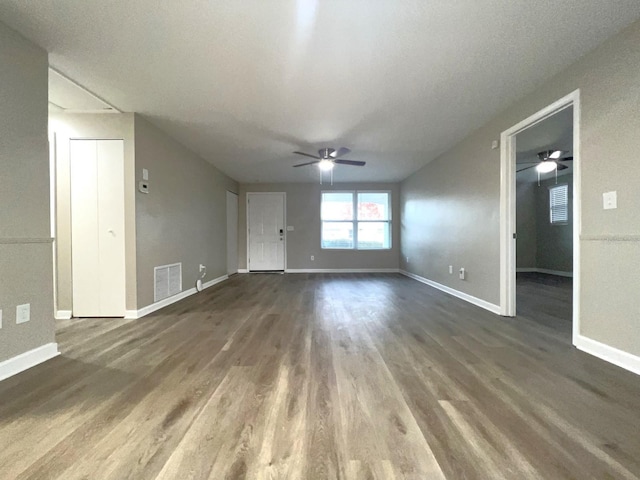 unfurnished living room with a textured ceiling, dark hardwood / wood-style floors, and ceiling fan