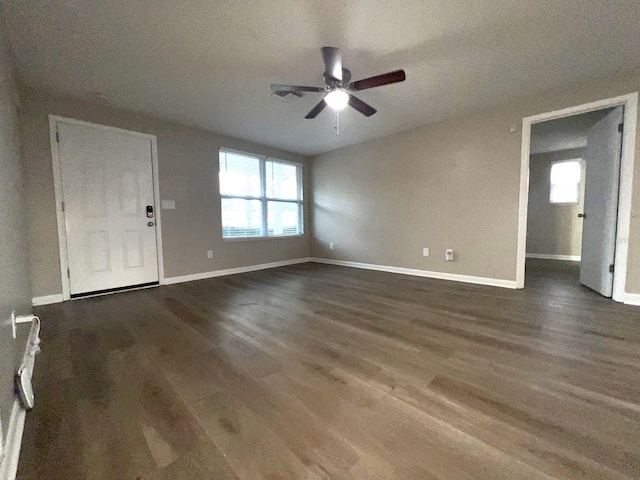 unfurnished living room featuring dark hardwood / wood-style floors and ceiling fan