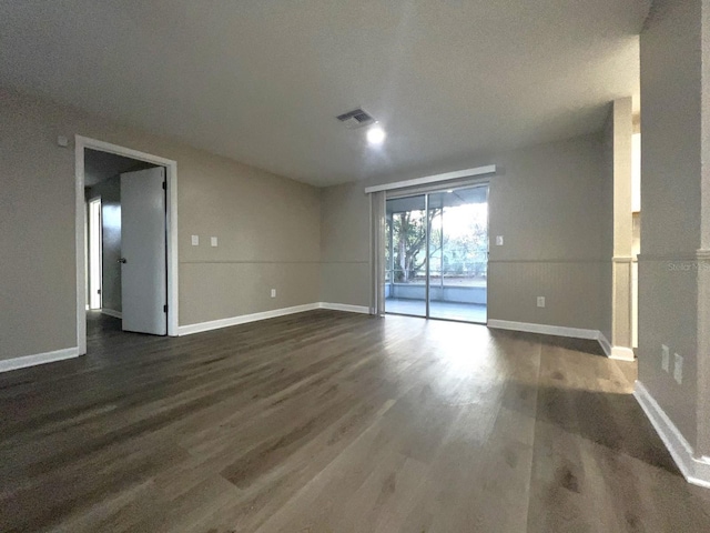 empty room with dark hardwood / wood-style flooring