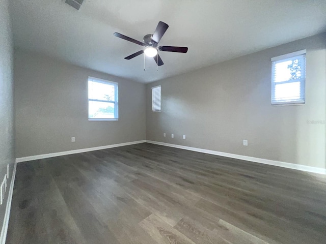 unfurnished room with ceiling fan and dark wood-type flooring