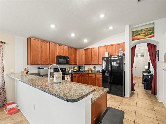 kitchen with kitchen peninsula, light tile patterned flooring, black appliances, and vaulted ceiling