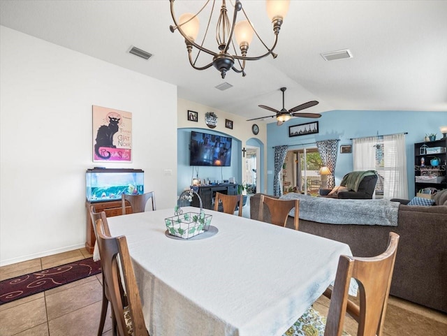 tiled dining room featuring ceiling fan with notable chandelier and lofted ceiling