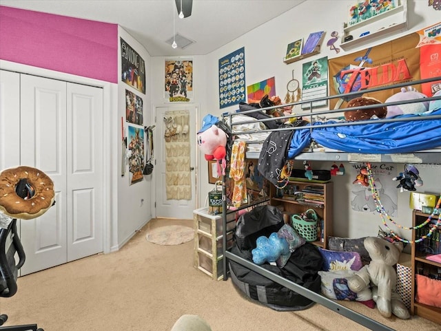 bedroom with ceiling fan, a closet, and carpet flooring