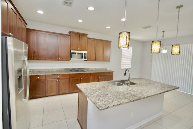 kitchen featuring hanging light fixtures, appliances with stainless steel finishes, sink, light tile patterned floors, and a center island with sink