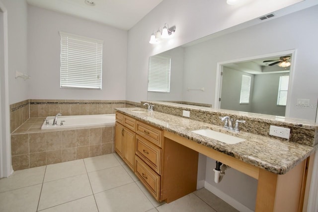 bathroom featuring tile patterned flooring, tiled bath, ceiling fan, and vanity