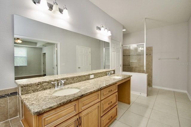 bathroom with vanity, a tile shower, and tile patterned flooring