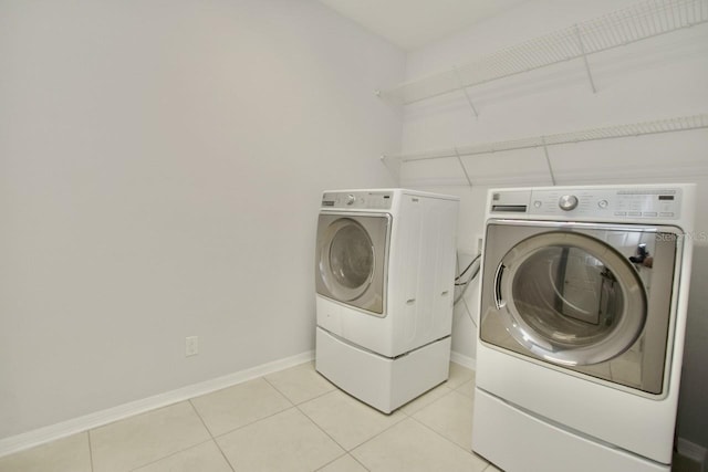 laundry room with washing machine and dryer and light tile patterned flooring