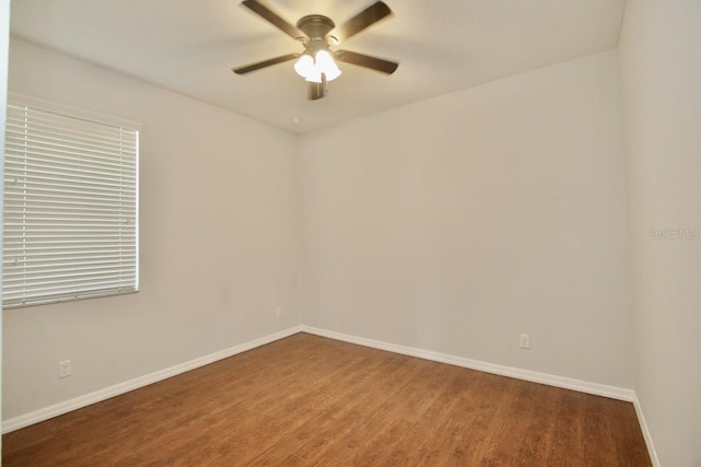 empty room with dark hardwood / wood-style floors and ceiling fan